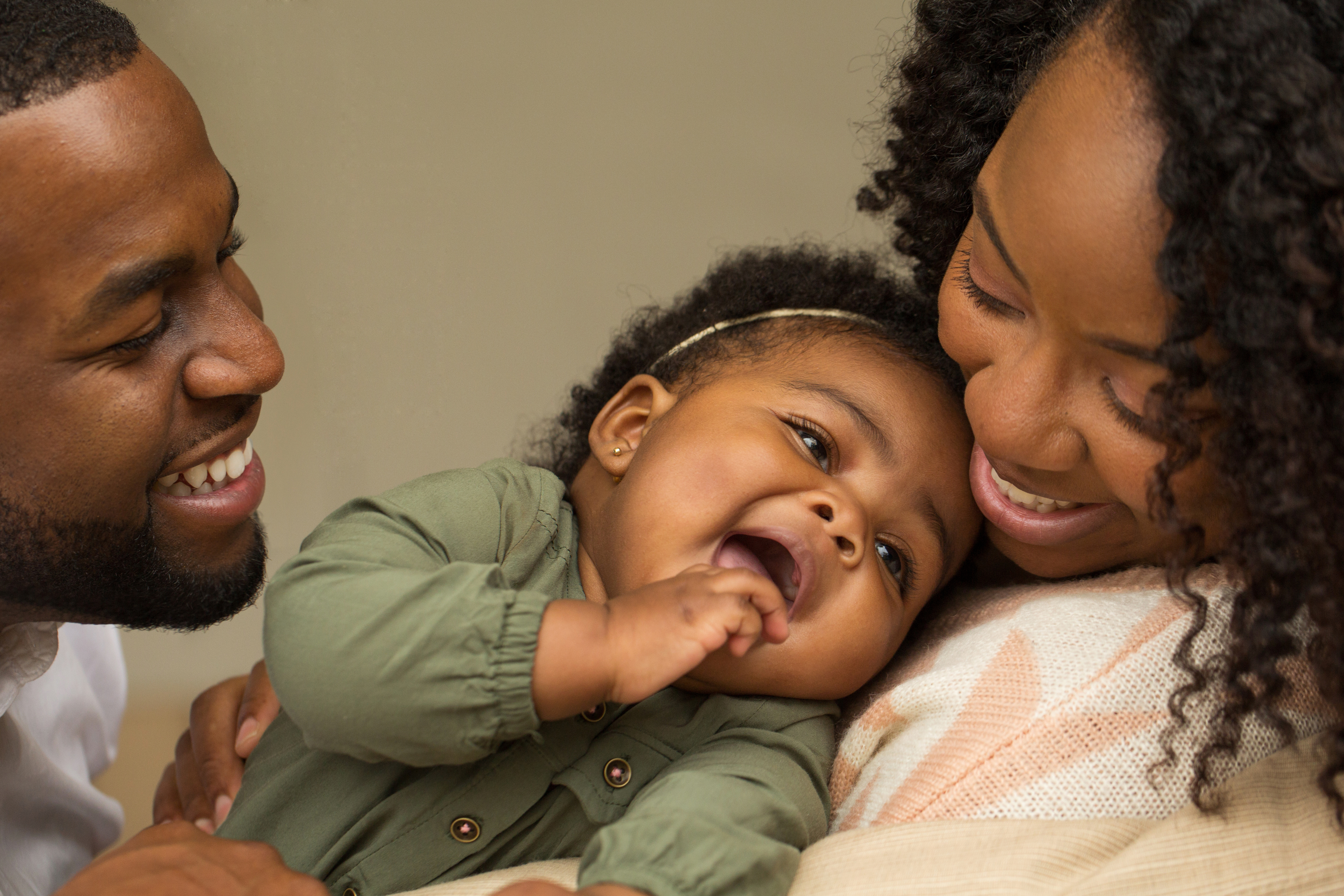 Mother and father, smiling and holding a happy baby